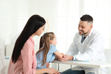 Little girl with mother visiting orthopedist at clinic