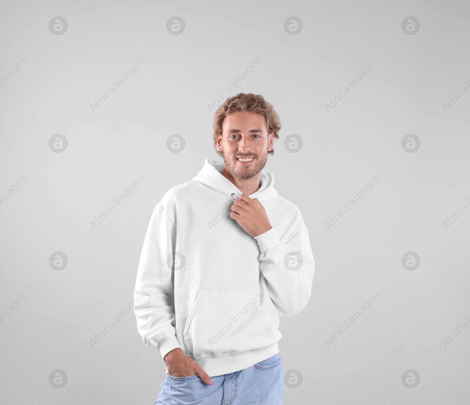 Photo of Portrait of man in hoodie sweater on light background. Space for design