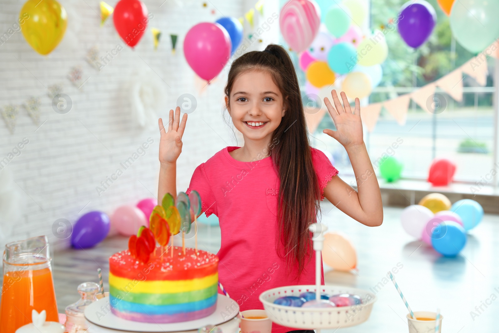 Photo of Happy girl in room decorated for birthday party