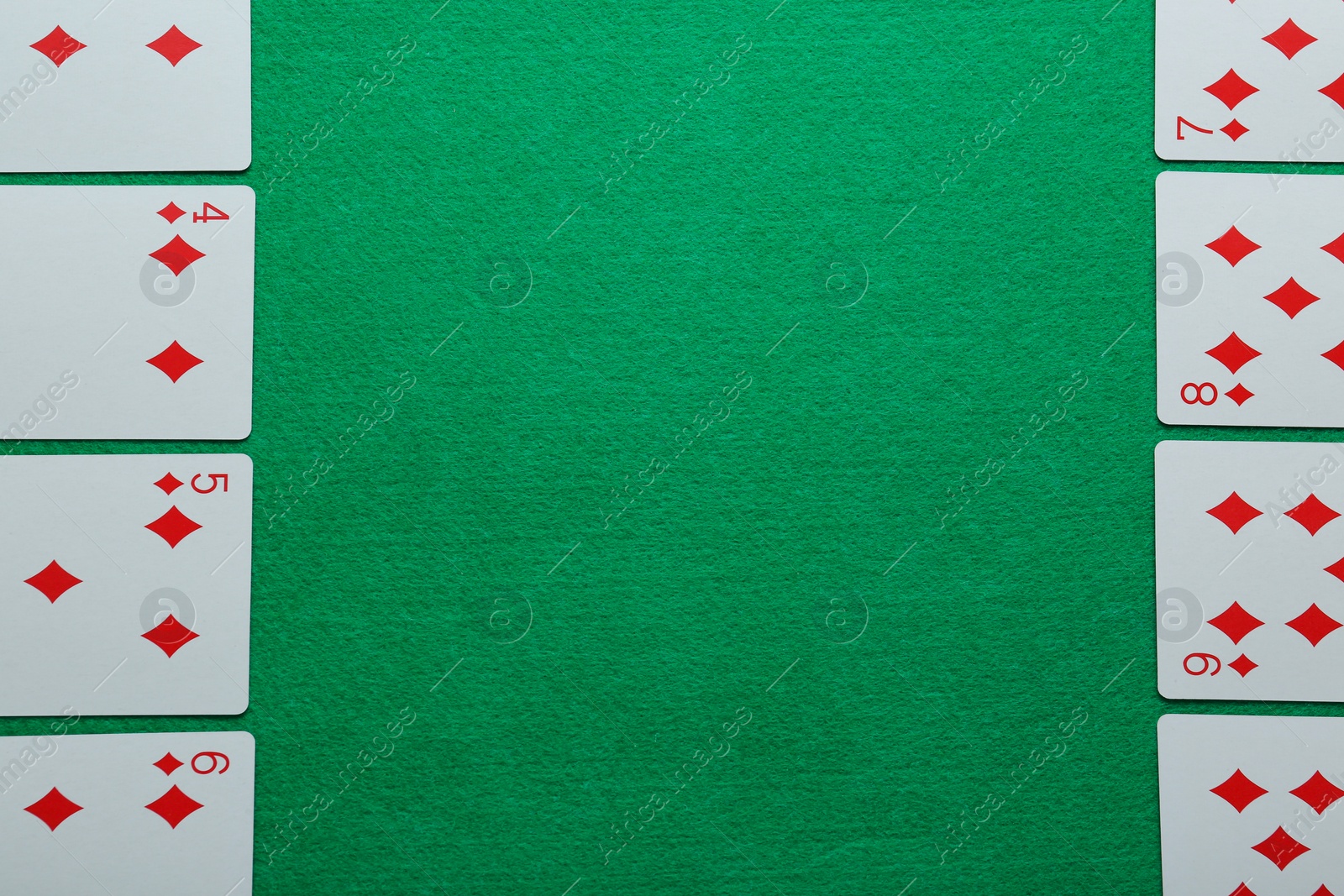 Photo of Playing cards on green table, flat lay. Space for text