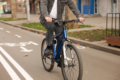 Photo of Man riding bicycle on lane in city, closeup