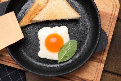 Photo of Sweet gummy fried egg and bread served as breakfast on wooden table, flat lay. April Fools' Day