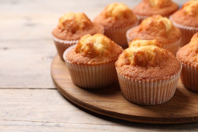 Photo of Delicious sweet muffins on wooden table, closeup. Space for text