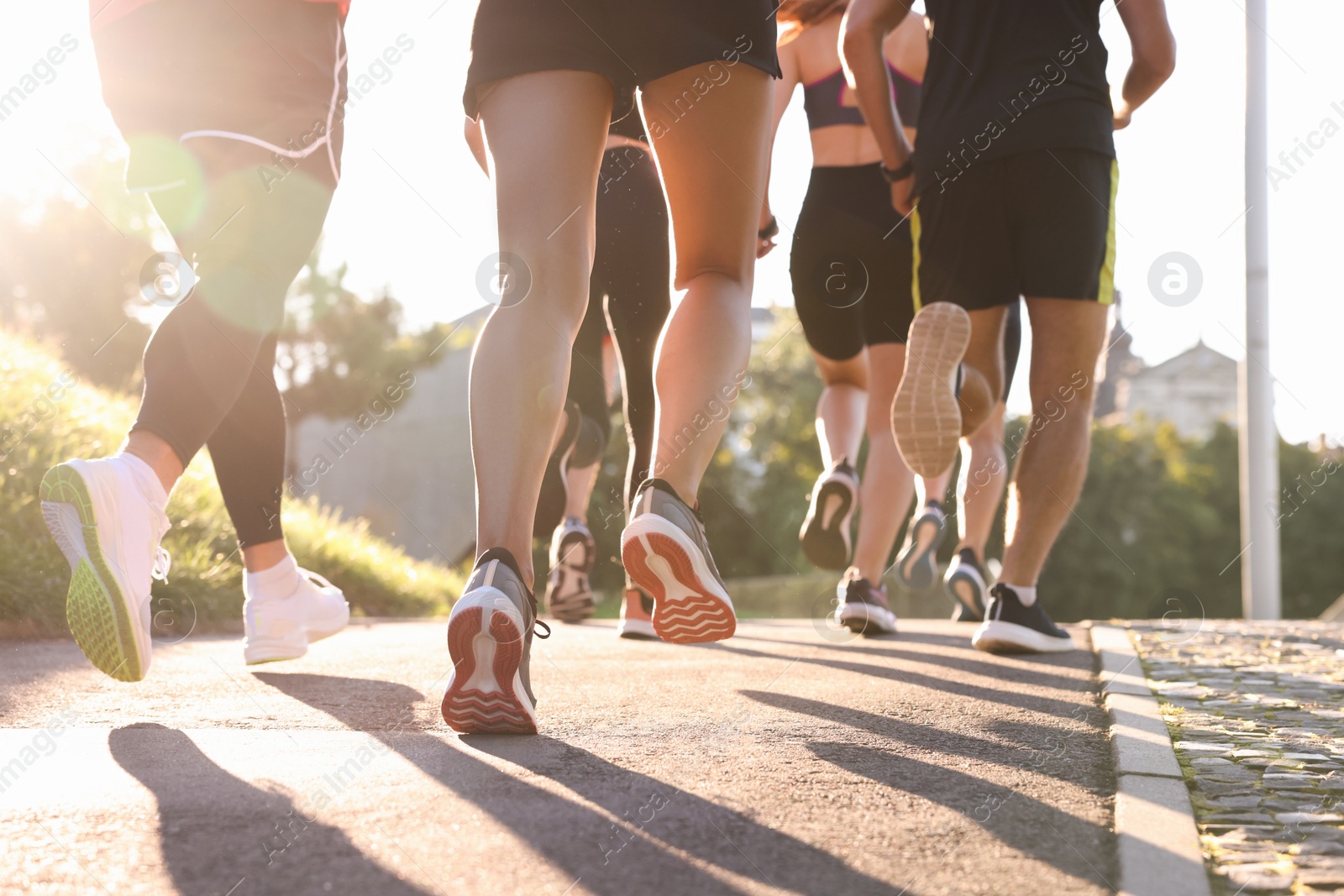 Photo of Group of people running outdoors on sunny day, closeup view