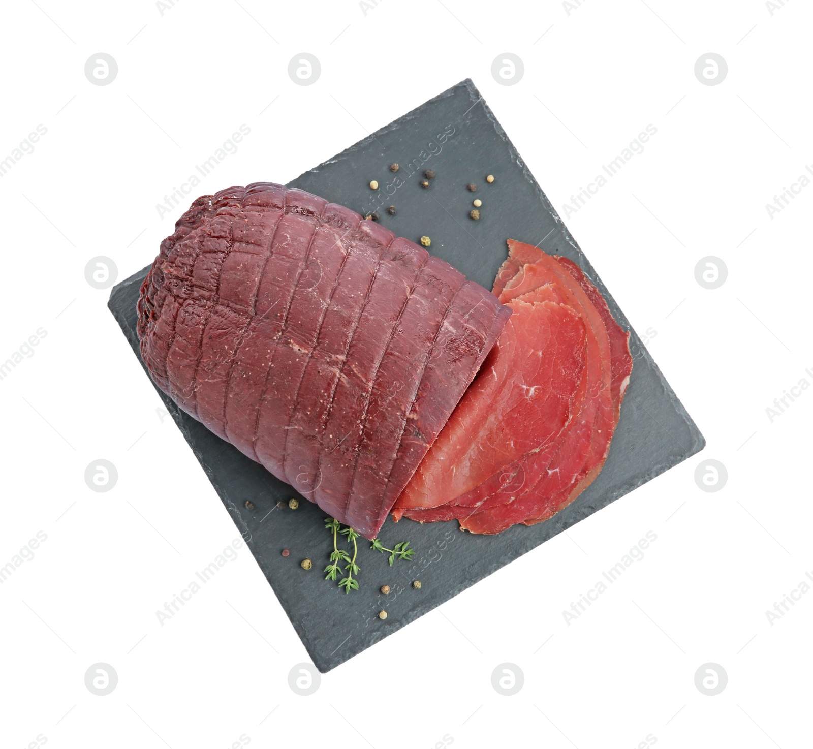 Photo of Tasty fresh dry bresaola, peppercorns and thyme isolated on white, top view