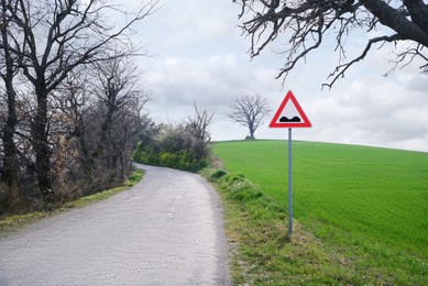 Photo of Asphalt road and traffic sign in countryside on sunny day