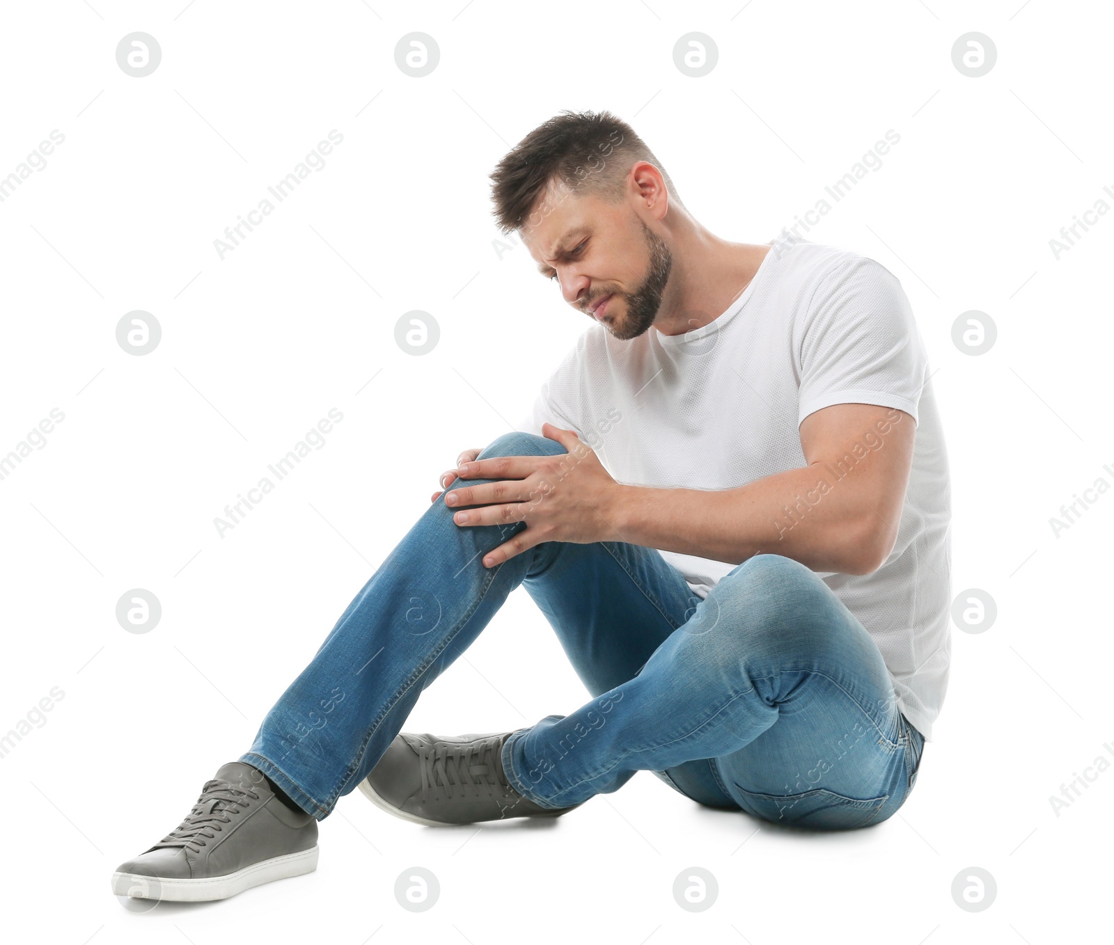 Photo of Full length portrait of man with knee problems sitting on white background