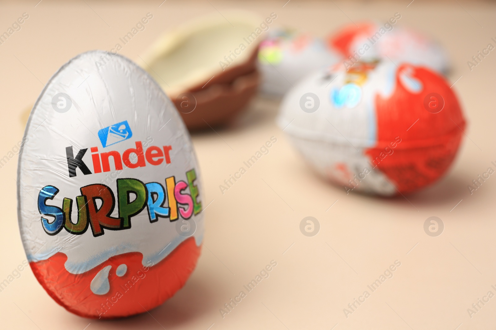 Photo of Slynchev Bryag, Bulgaria - May 25, 2023: Kinder Surprise Eggs on beige background, closeup. Space for text