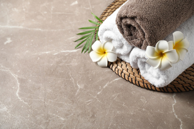Photo of Beautiful spa composition with plumeria flowers on grey marble table, above view. Space for text