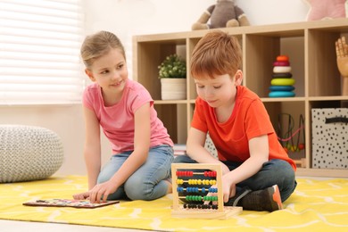 Photo of Children playing with math game kits on floor in room. Learning mathematics with fun