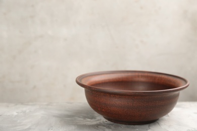 Photo of Clay bowl on grey table, space for text. Handmade utensil