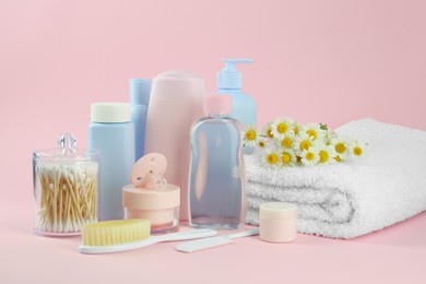 Photo of Different skin care products for baby, flowers and accessories on pink background