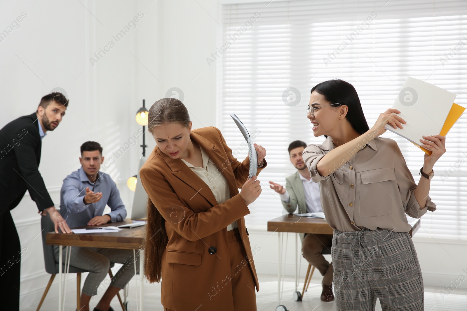 Photo of Emotional colleagues fighting in office. Workplace conflict