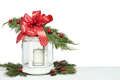 Decorated Christmas lantern with burning candle on white wooden table, space for text