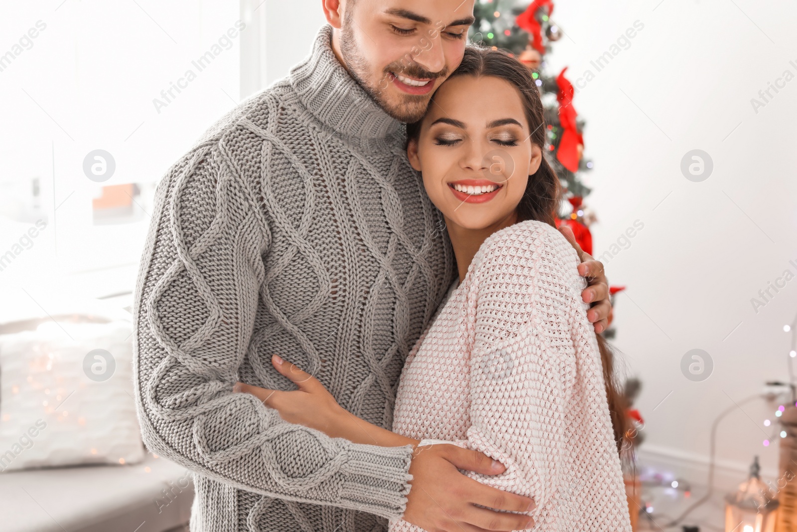 Photo of Happy young couple celebrating Christmas at home