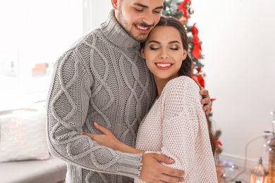 Photo of Happy young couple celebrating Christmas at home