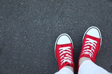 Photo of Woman standing on asphalt, top view. Space for text