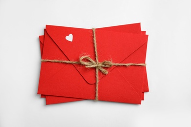 Photo of Stack of red envelopes on white background, top view. Love letters