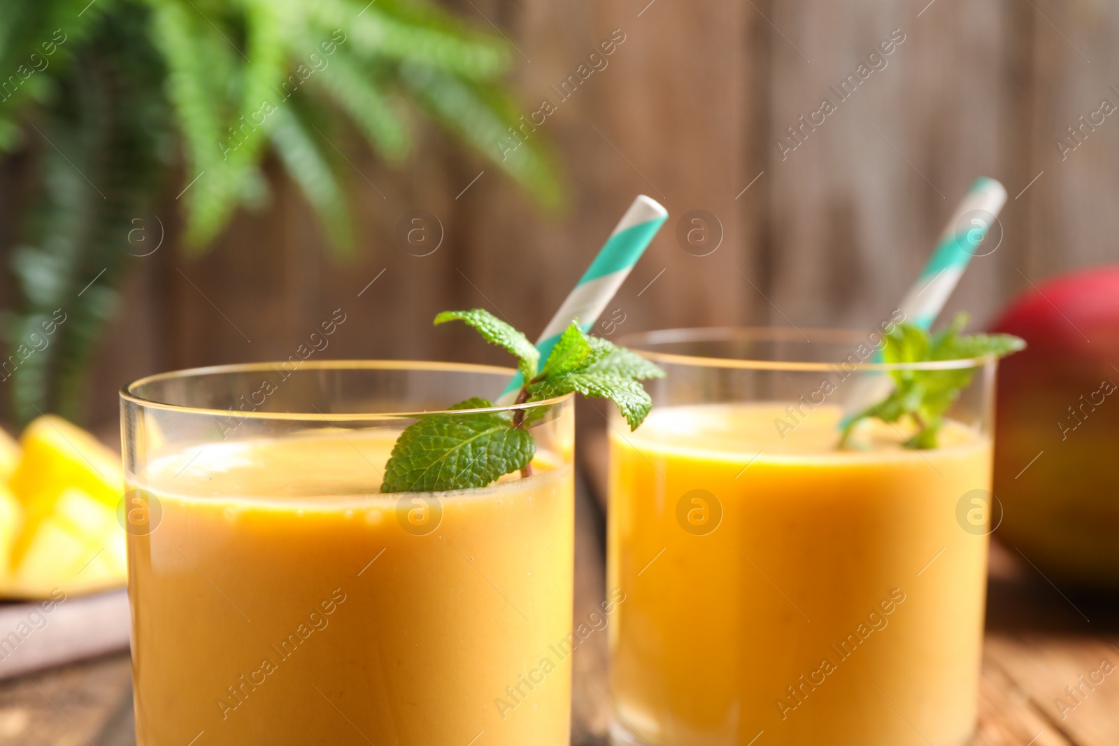 Photo of Fresh delicious mango drink on table, closeup