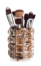 Photo of Glass holder with professional makeup brushes on white background