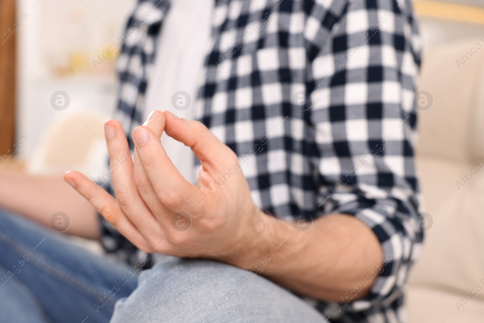 Photo of Man meditating indoors, closeup. Harmony and zen