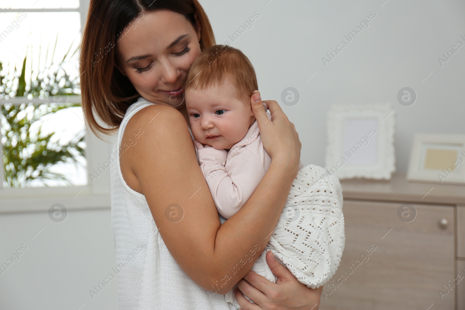 Photo of Young woman with her little baby resting after breast feeding at home