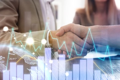 Image of Double exposure with charts and photo of business partners shaking hands