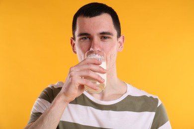 Photo of Milk mustache left after dairy product. Man drinking milk on orange background