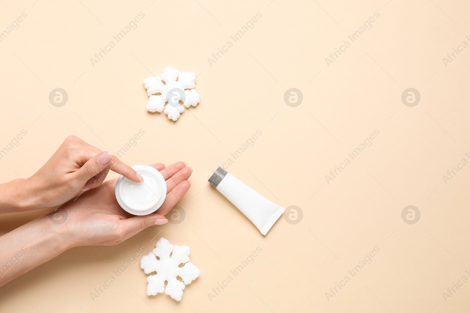 Photo of Woman with jar of hand cream on beige background, top view. Space for text