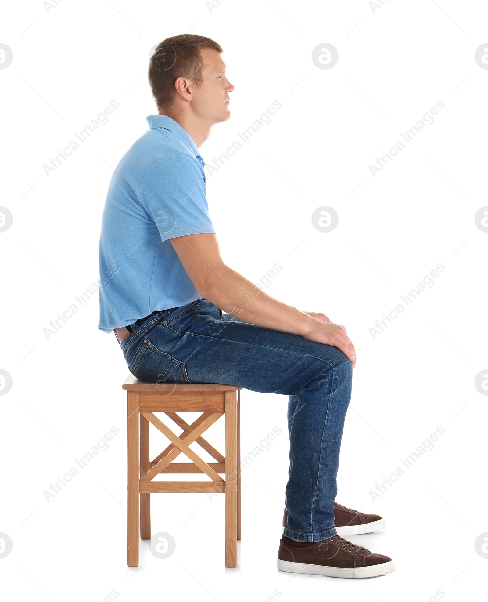 Photo of Man sitting on stool against white background. Posture concept