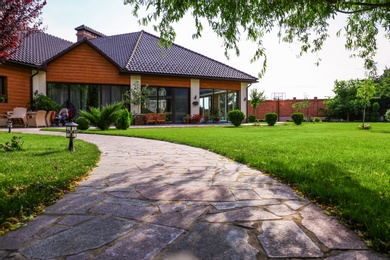 Beautiful landscape with green garden near modern house on sunny day