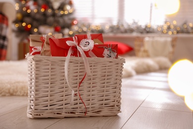 Photo of Basket full of gifts in paper bags for Christmas advent calendar at home, space for text