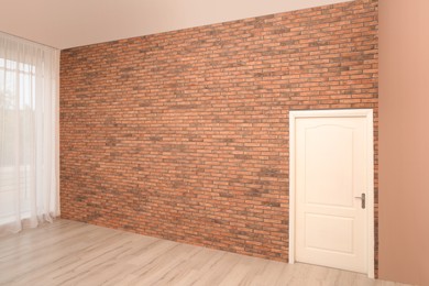 Empty room with brick wall, white door and laminated floor