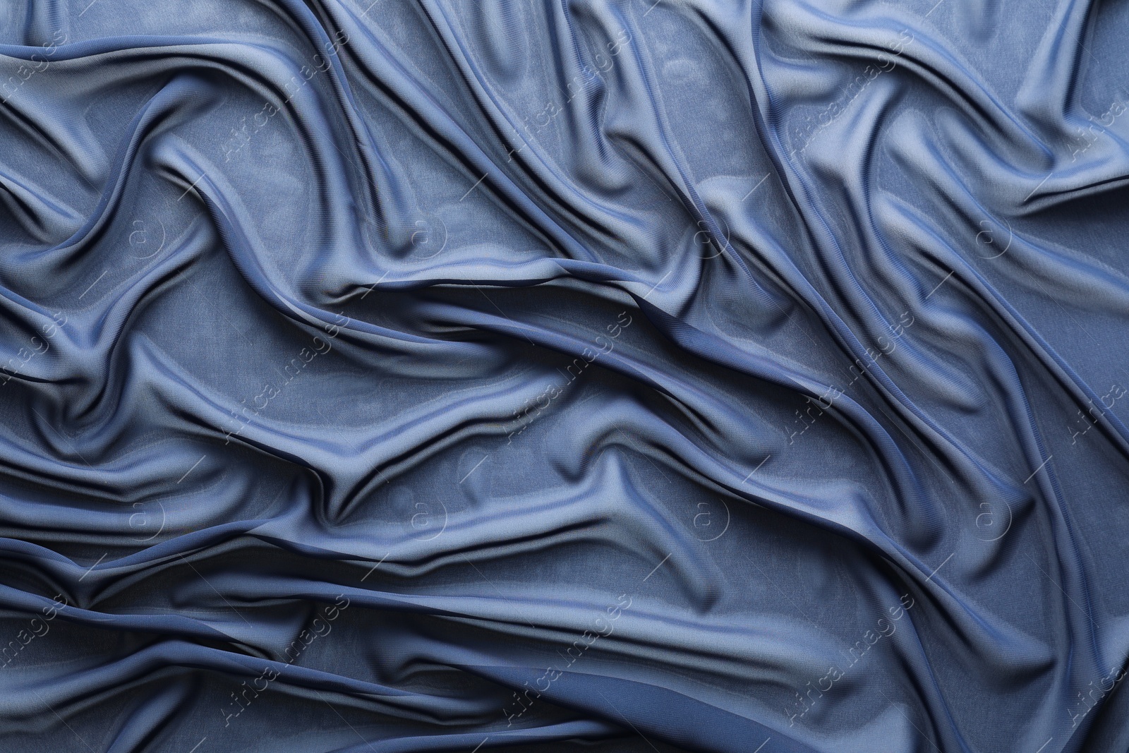 Photo of Beautiful dark blue tulle fabric as background, top view