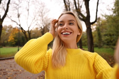 Photo of Portrait of happy woman taking selfie in autumn park