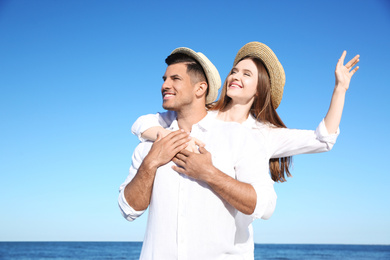 Lovely couple wearing hats together on beach