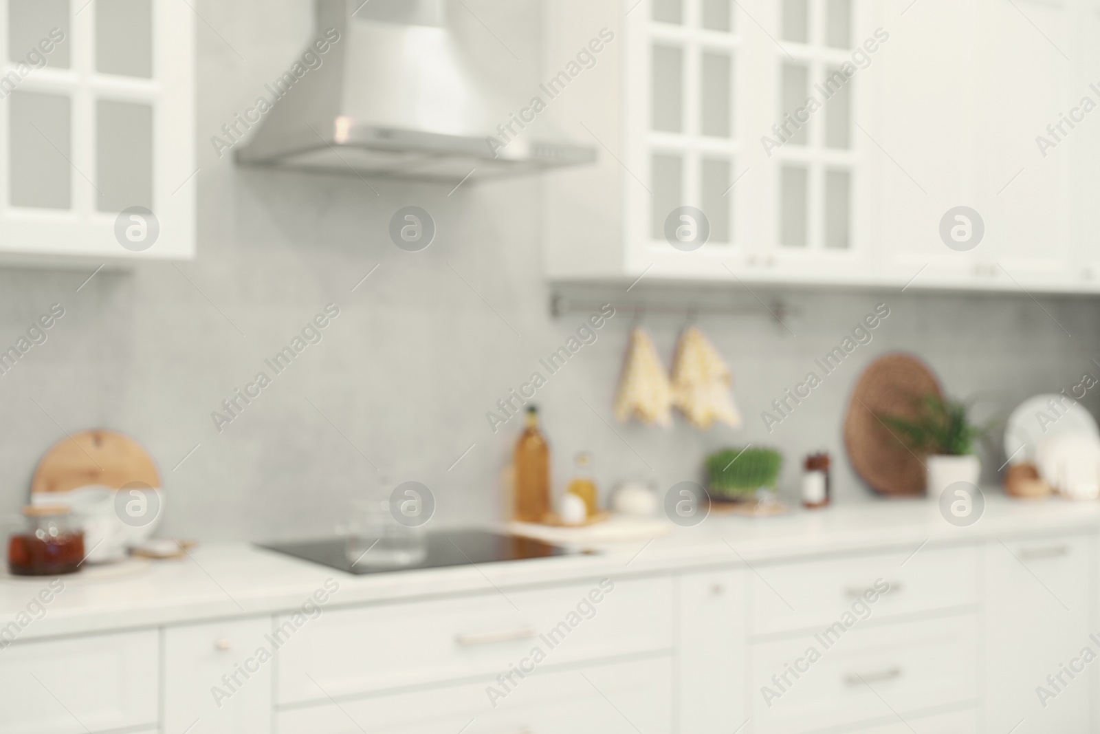 Photo of White cosy kitchen with furniture, blurred view. Interior design