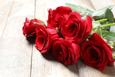 Photo of Beautiful red rose flowers on wooden background