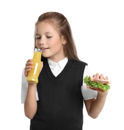Photo of Happy girl holding sandwich and bottle of juice on white background. Healthy food for school lunch