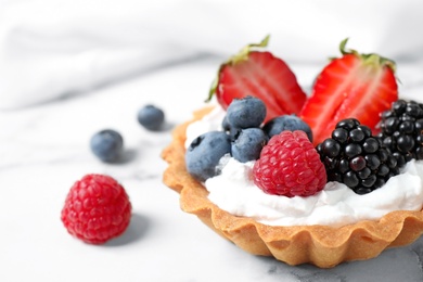 Photo of Tart with different berries on marble table, closeup. Delicious pastries