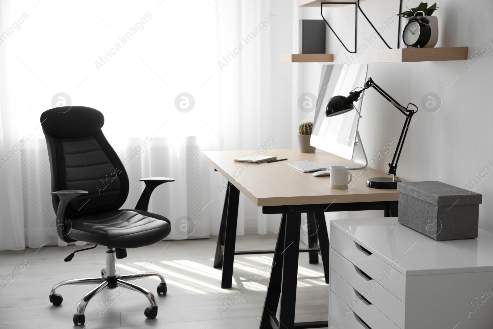 Photo of Comfortable office chair near table with modern computer