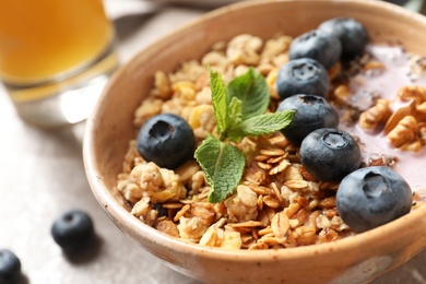 Bowl of tasty oatmeal with blueberries and yogurt on table, closeup