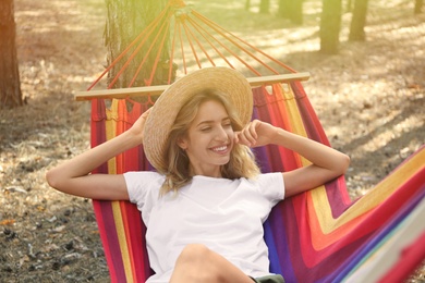 Woman resting in hammock outdoors on summer day