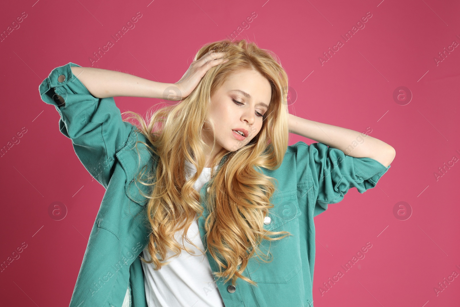 Photo of Portrait of beautiful young woman with dyed long hair on pink background