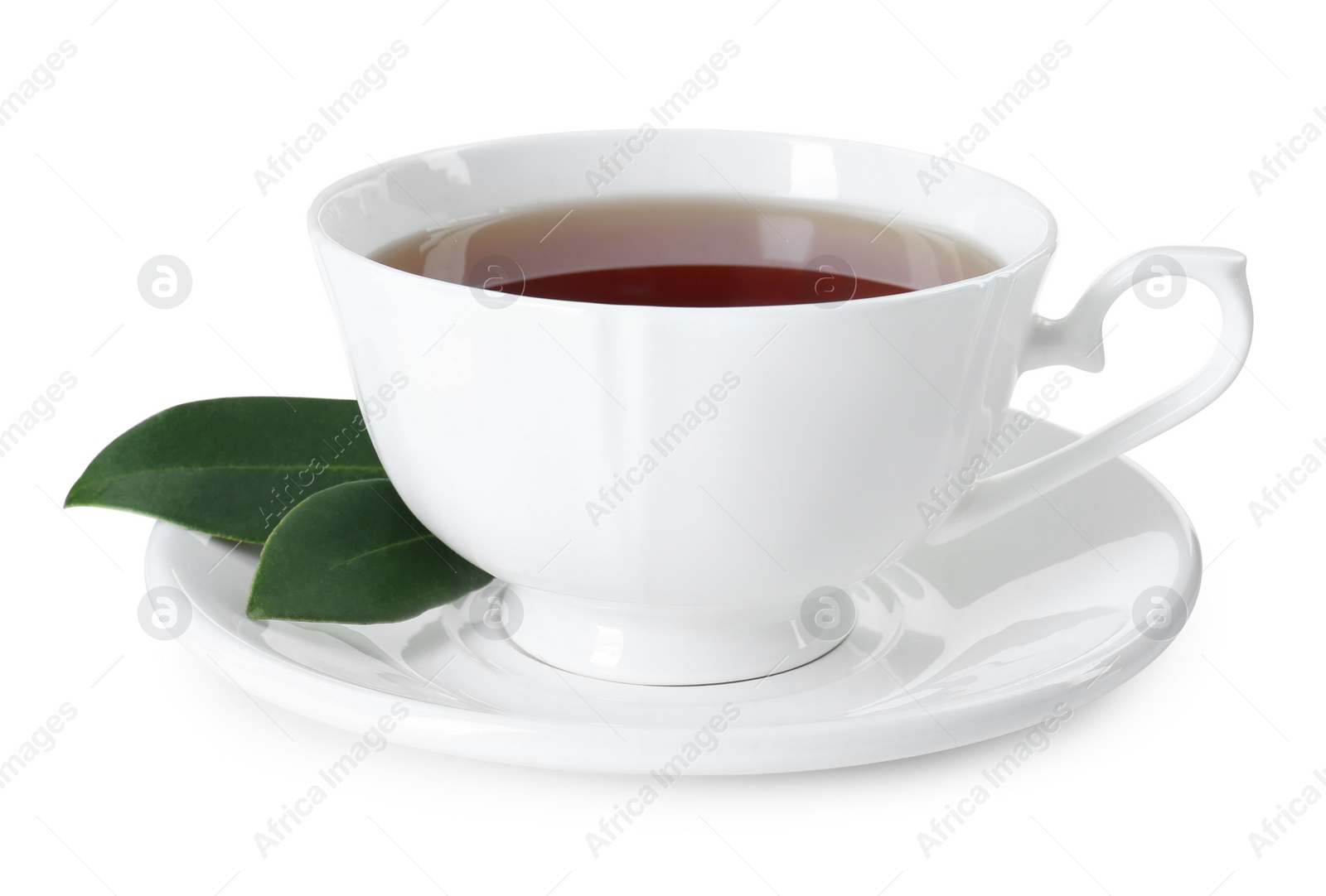 Photo of Aromatic tea in cup and green leaves isolated on white