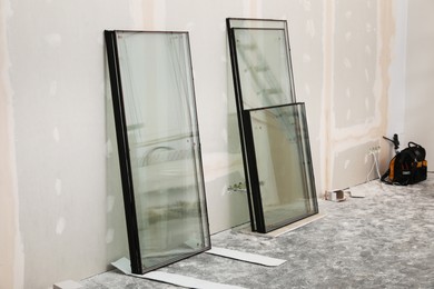 Photo of Double glazing windows on floor near plasterboard wall indoors