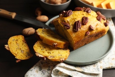 Delicious pumpkin bread with pecan nuts on wooden table