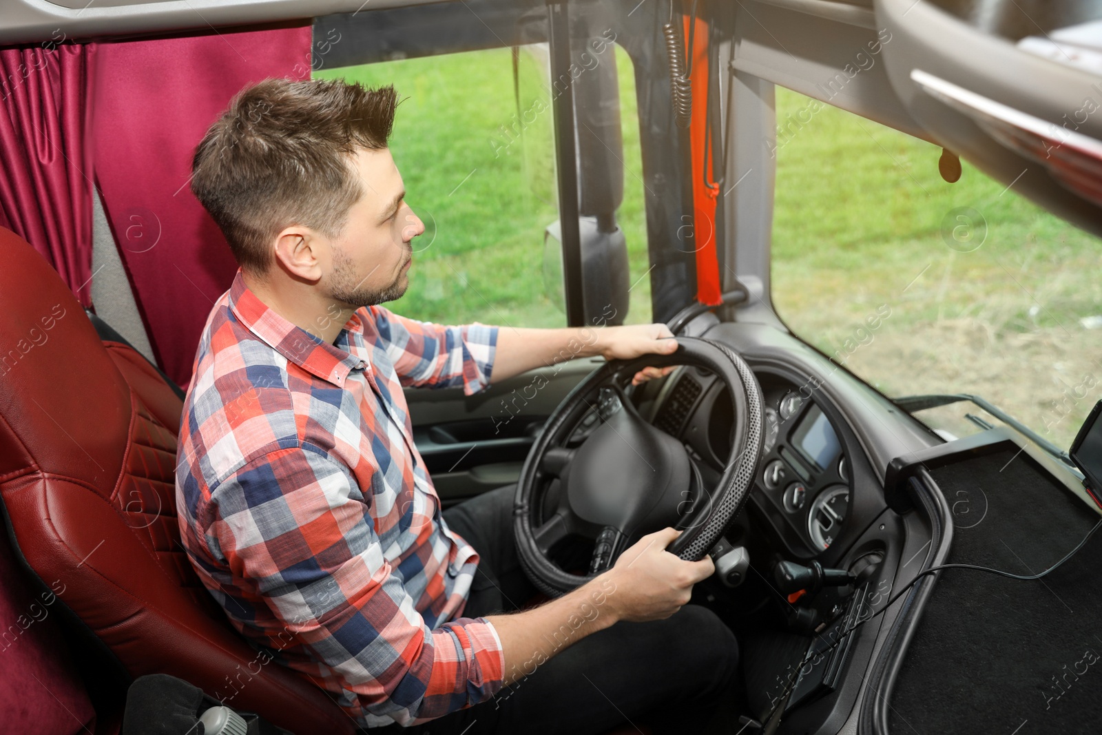 Photo of Professional driver sitting in cab of modern truck