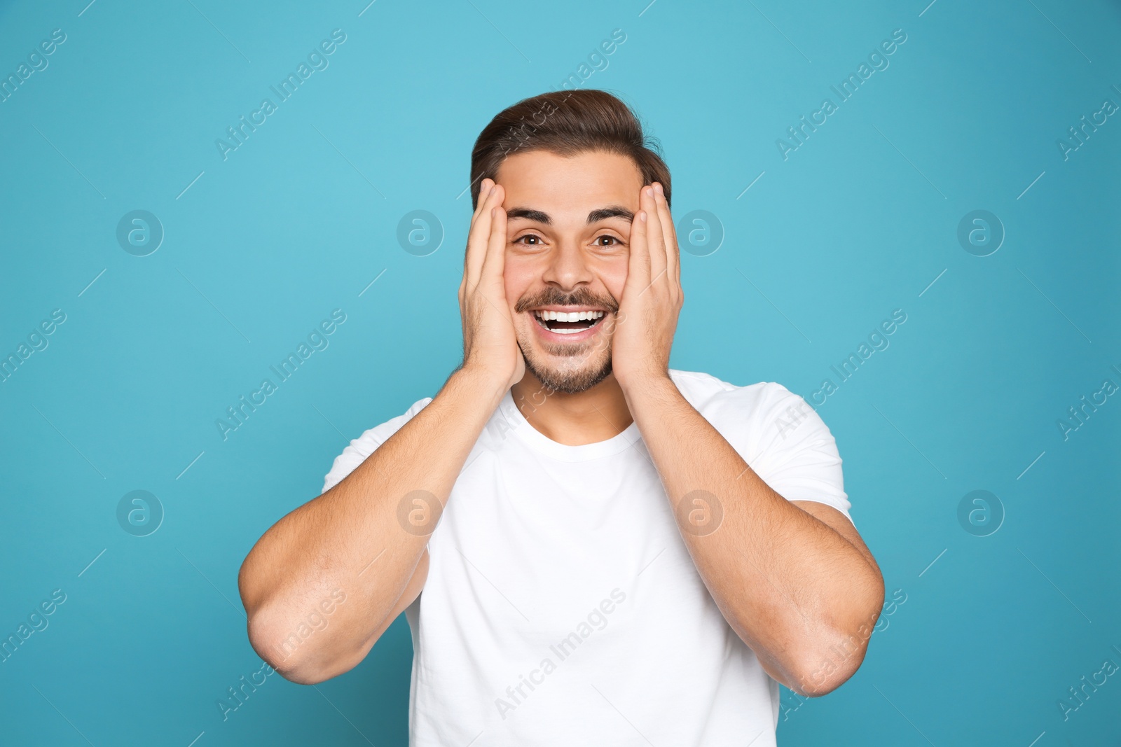 Photo of Portrait of young man laughing on color background