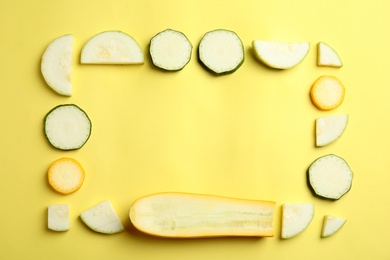 Photo of Fresh ripe cut zucchinis on yellow background, flat lay. Space for text